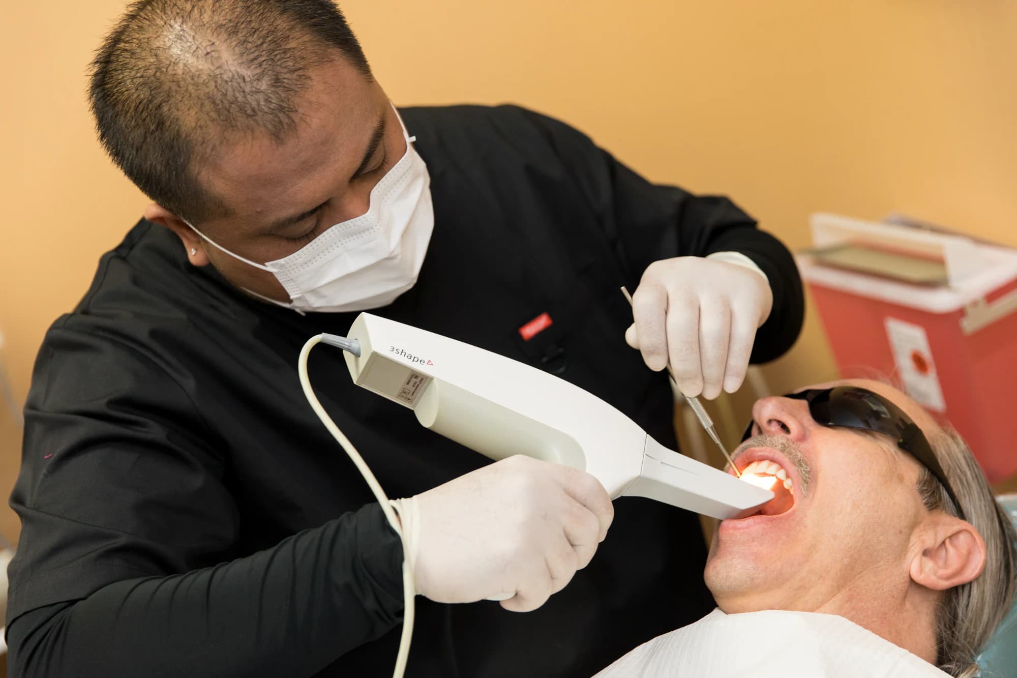 Digital intraoral scanner capturing impressions during a dental implant consultation