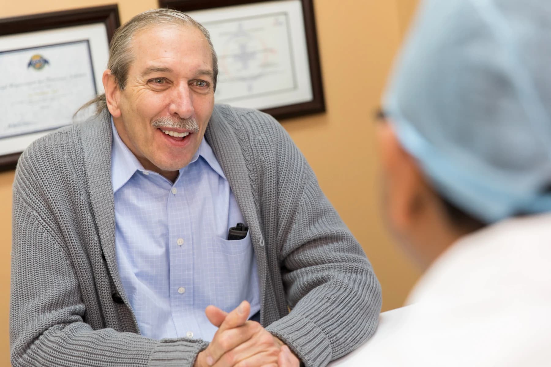 A patient laughing with his clinician during a consultation
