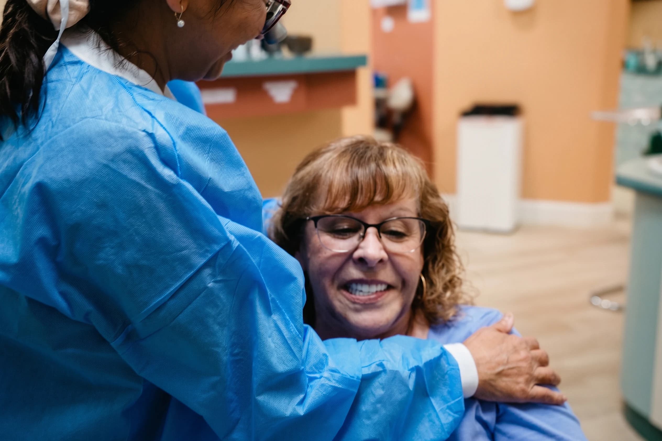 A patient embracing her surgeon after treatment