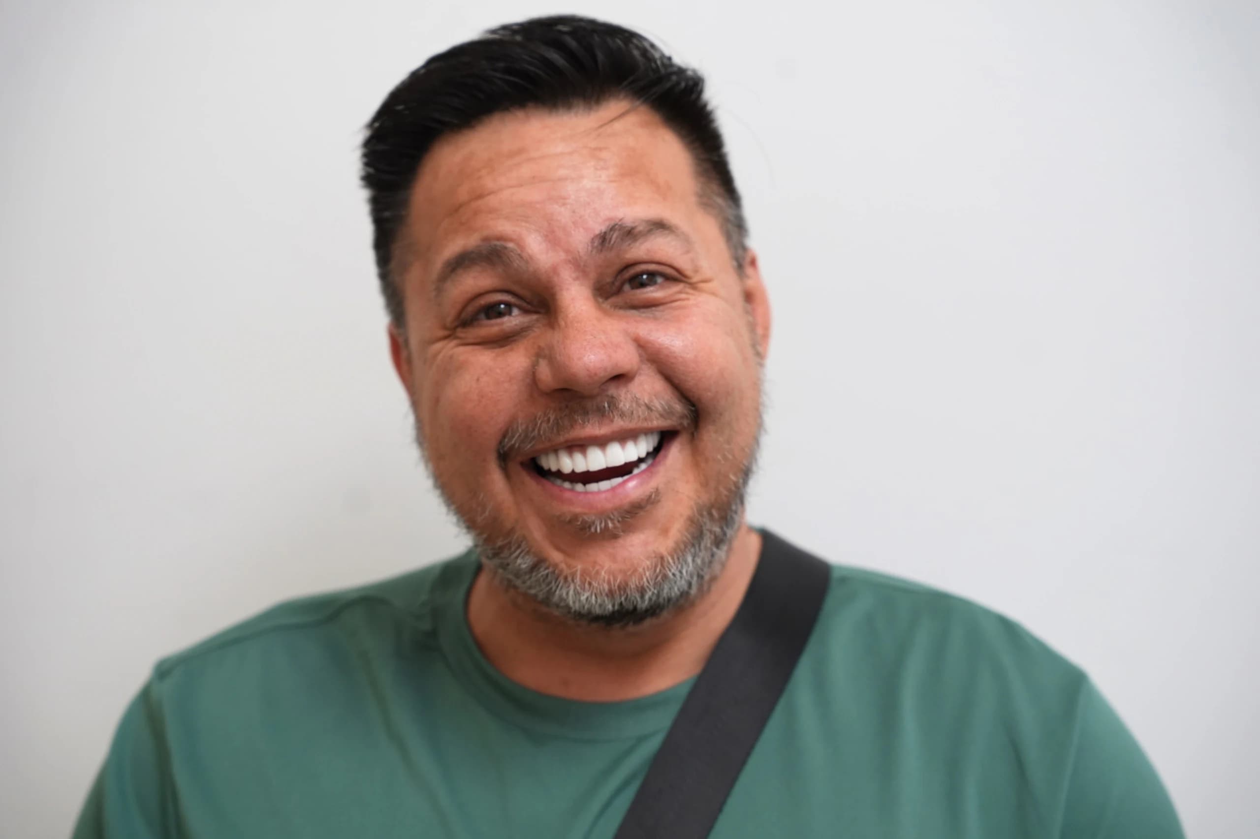 An implant patient smiling for his portrait
