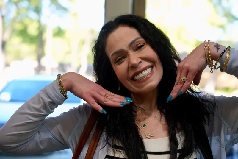 A patient framing her new smile with both hands