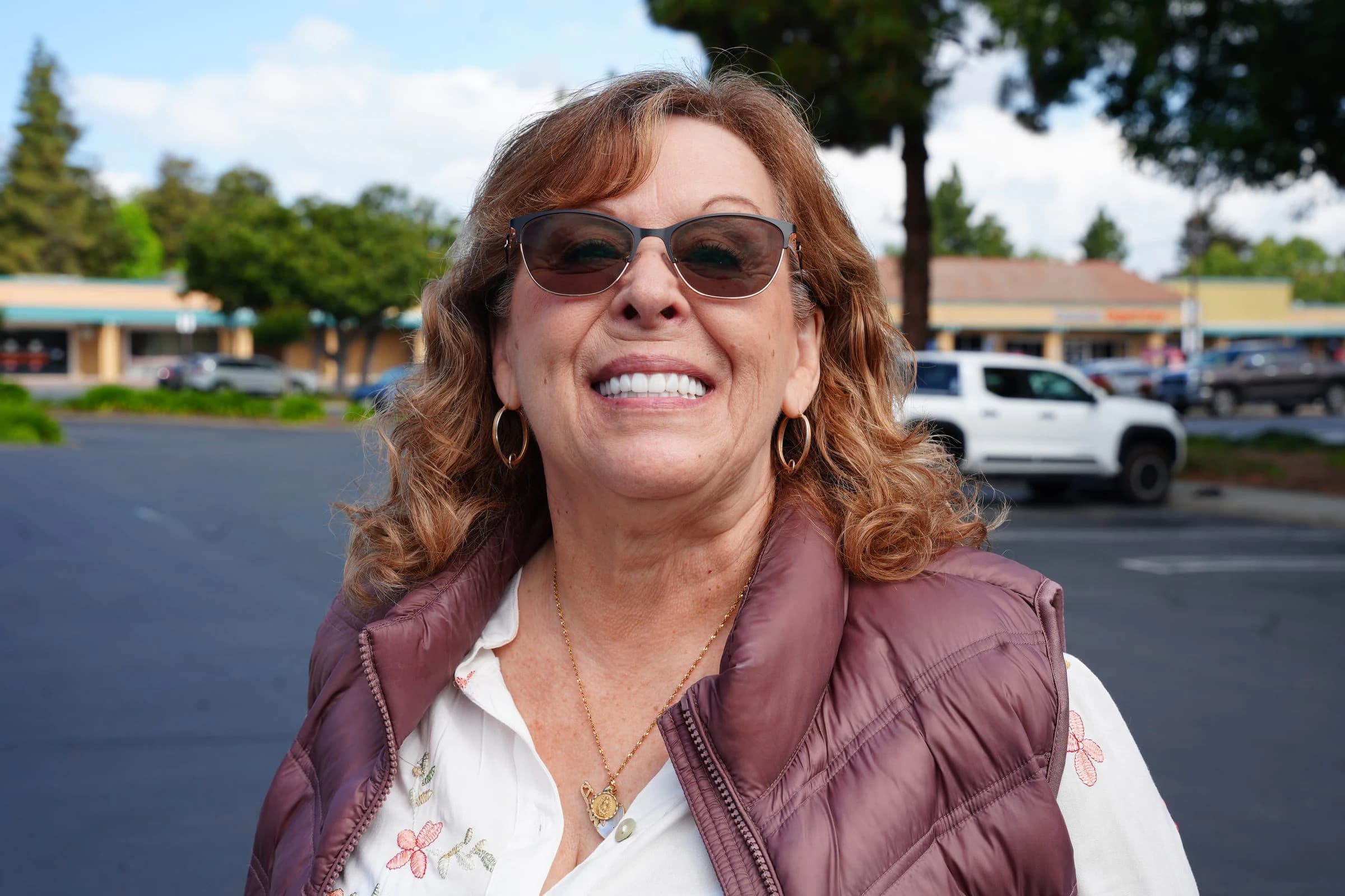 A patient smiling outside the practice