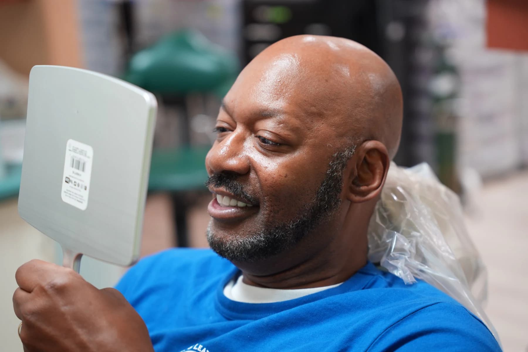 A patient studying his smile in a hand mirror