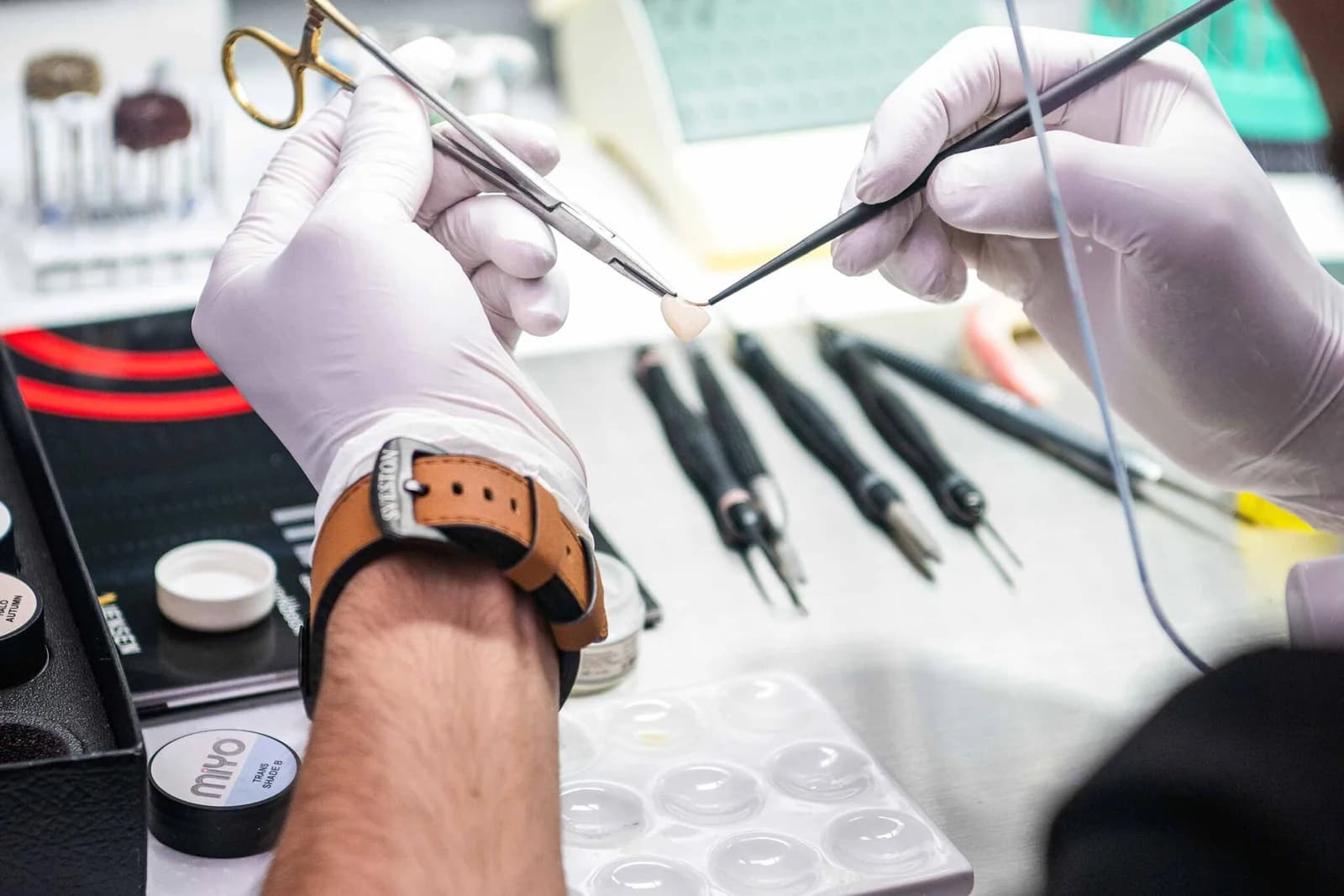 A technician staining a crown by hand at the bench