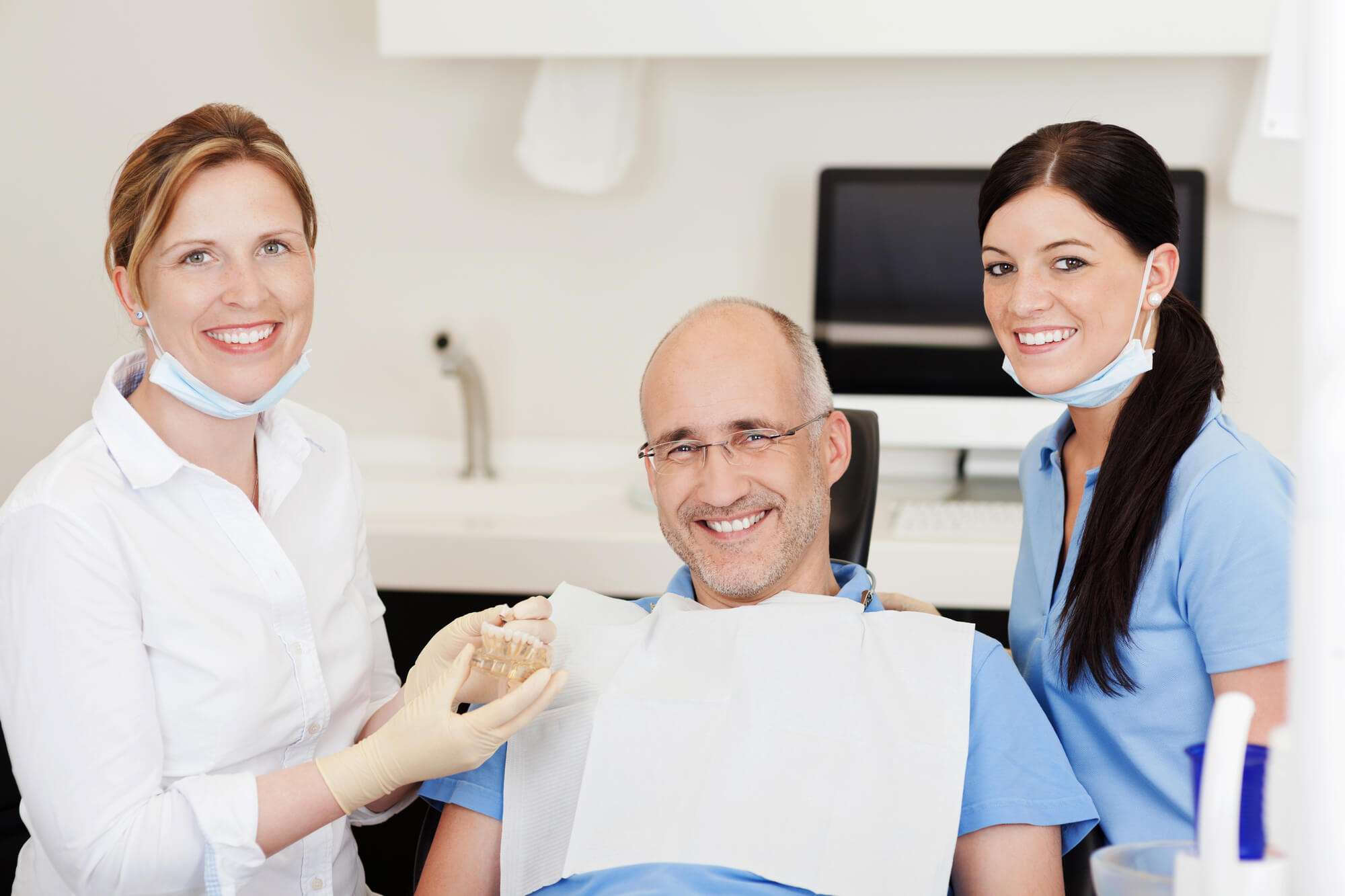 an Implant Dentist Fremont in CA with an assistant and an older male patient